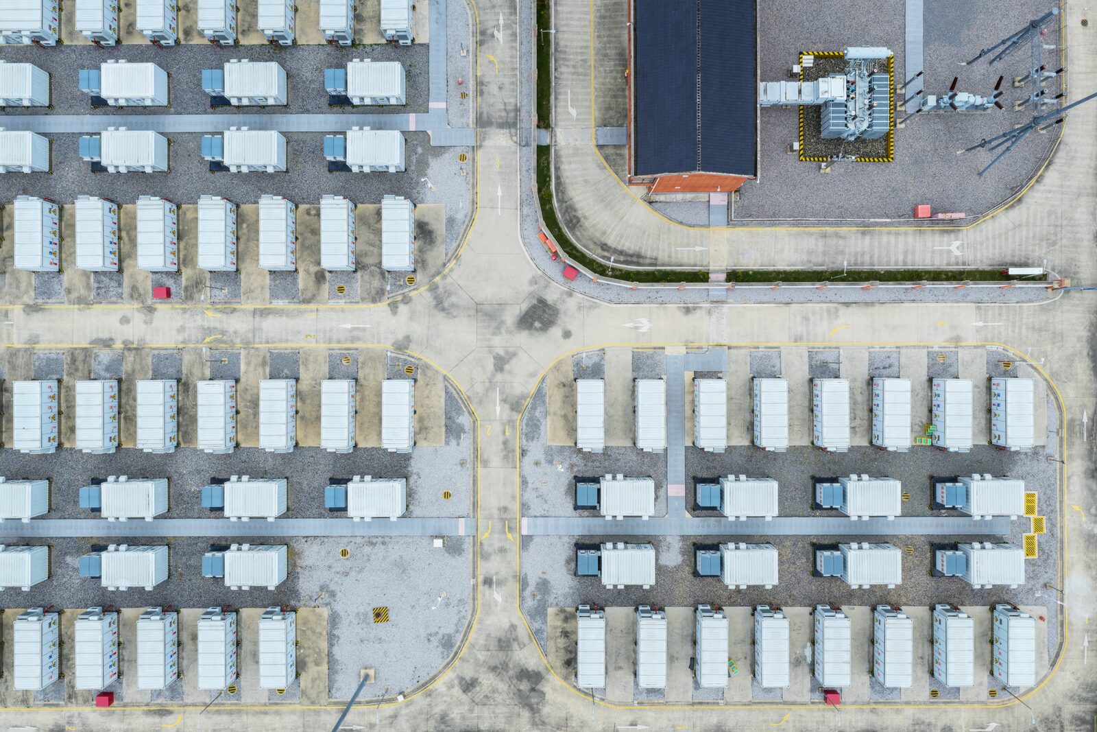 Overhead view of battery containers arranged in rows on a gravel pad